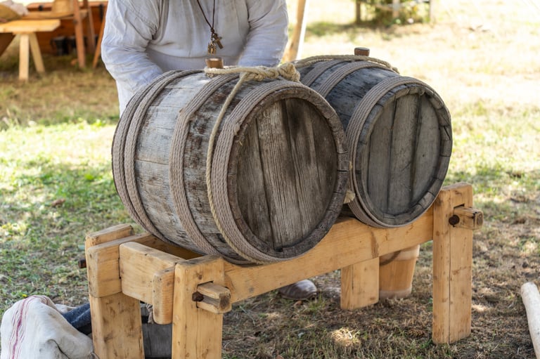 Close-up view of traditional wooden barrels on a rustic stand with warm tones